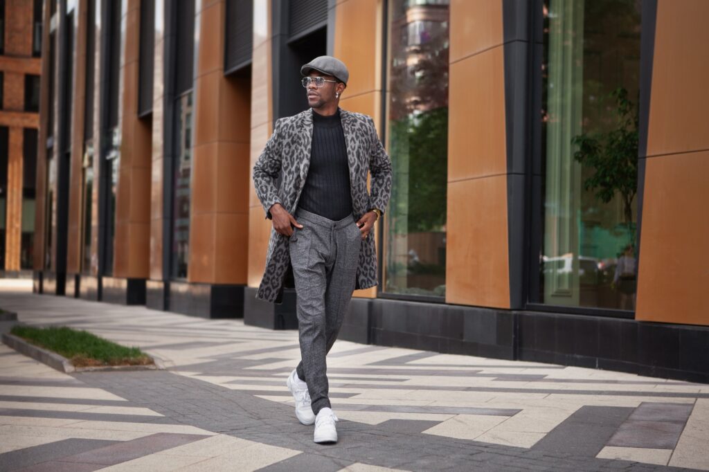 Fashion Man Wearing Fashionable Clothes gray coat animal print, turtleneck, cap, trousers and white