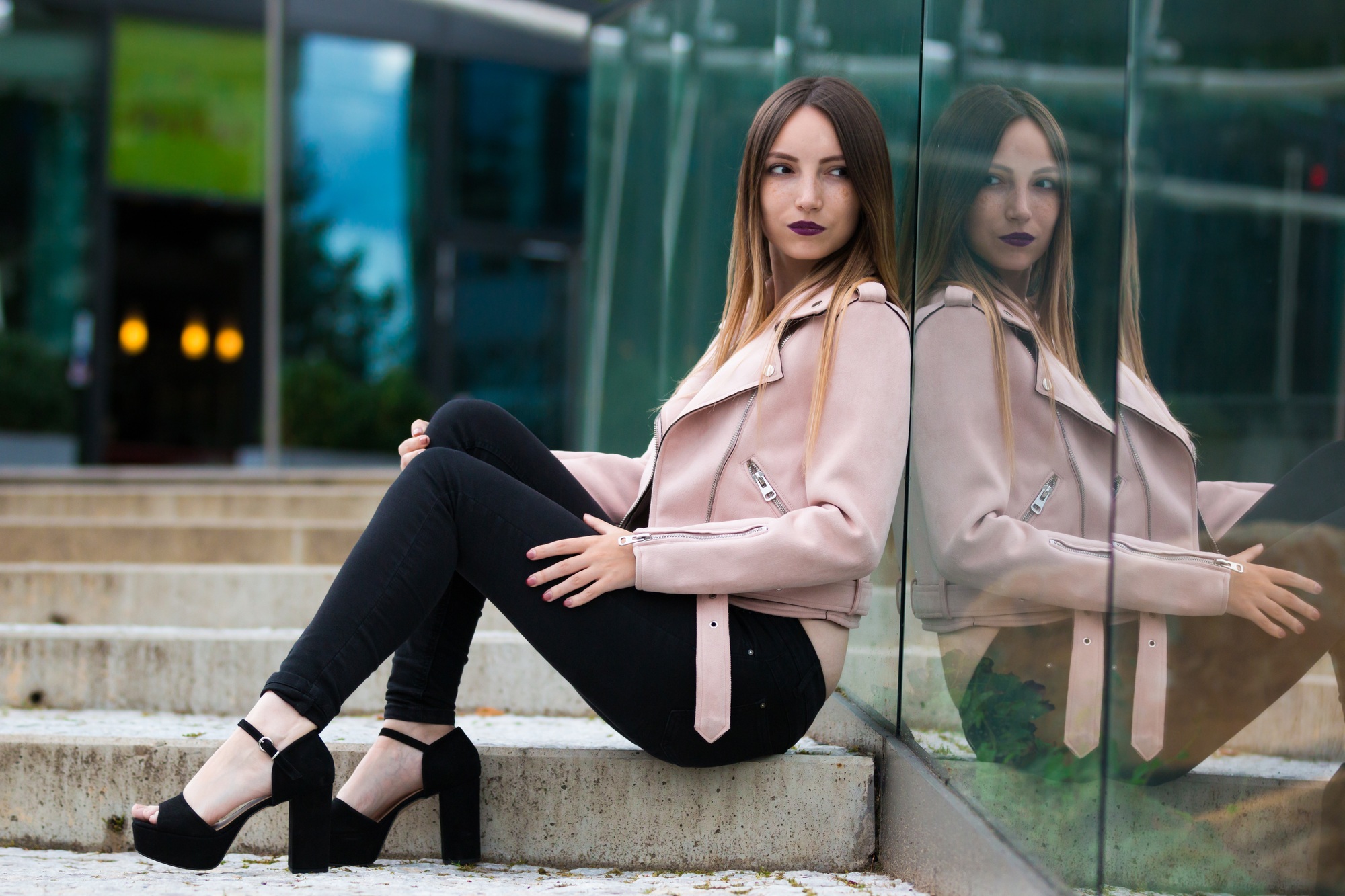 Reflexion of modern fashion girl in glass building